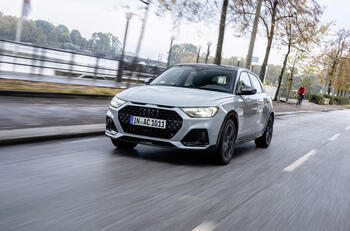 Grey Audi A1 driving down a city street