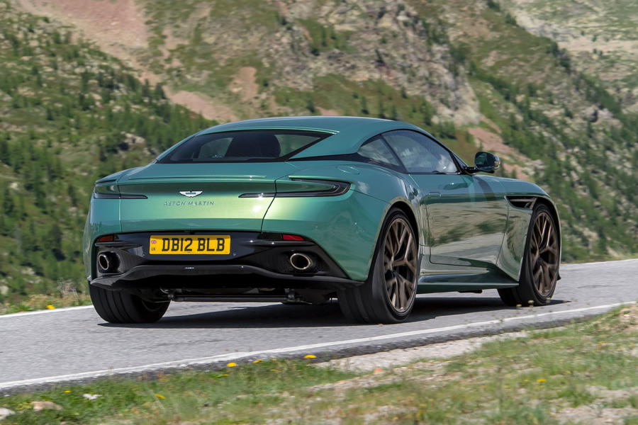 Aston Martin DB12 dirigindo em estrada de montanha – quarto traseiro
