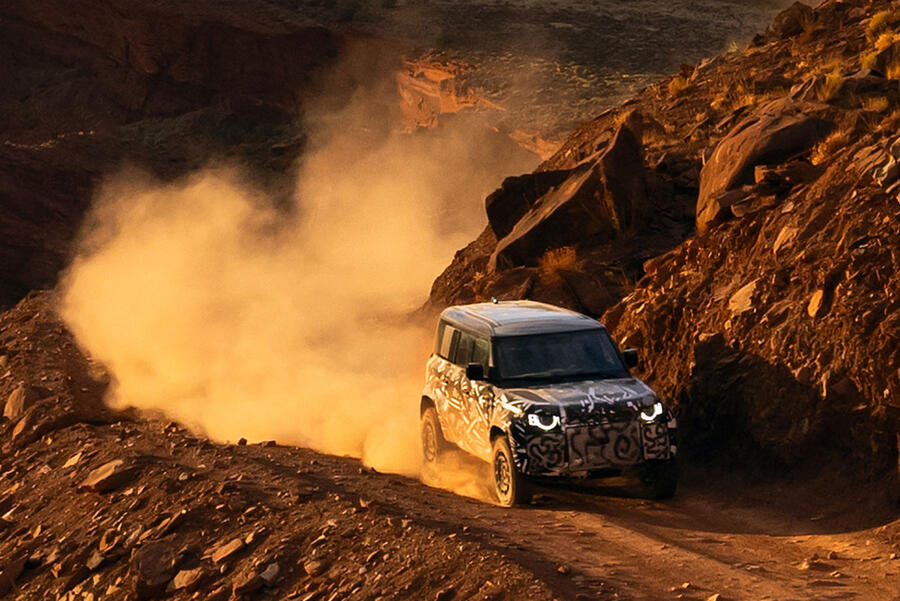 Defender Octa teaser image â€“ driving on dusty canyon road