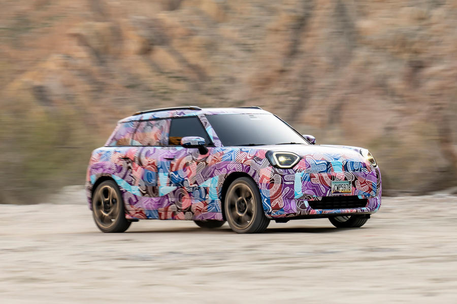 Camouflaged Mini Aceman driving off-road – front quarter