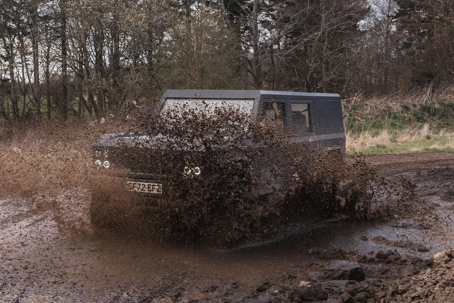 Munro Mk1 driving through mud splash – front quarter