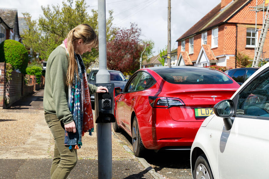 Tesla Model 3 parked in front of lamppost EV charger