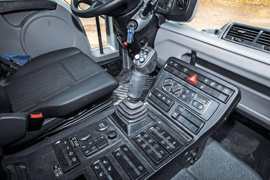A close-up shot of a Unimog's complex centre console, featuring an array of switchgear and a joystick with two buttons