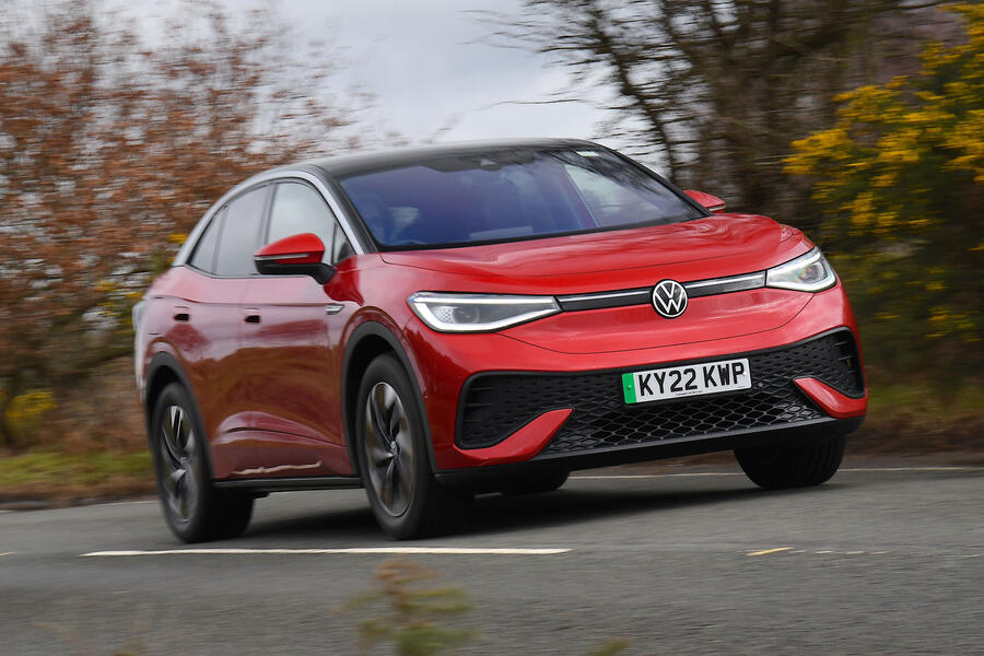 Red Volkswagen ID 5 front quarter driving in autumn