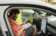 Person working on laptop from car Person working on laptop from car