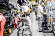 Staff building cars on production line Staff building cars on production line