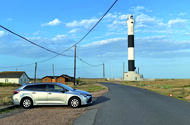 Toyota Corolla next to a lighthouse Toyota Corolla next to a lighthouse