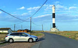 Toyota Corolla next to a lighthouse