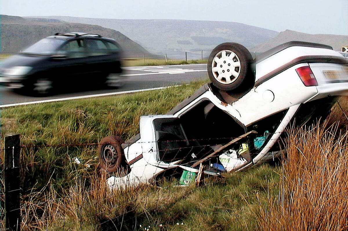 Car upside down at the side of a road