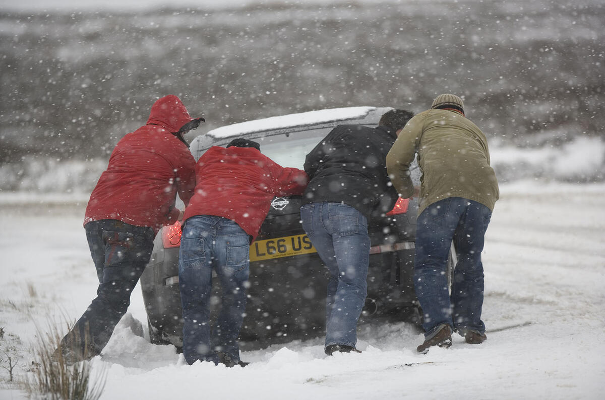 Pushing car stuck in snow