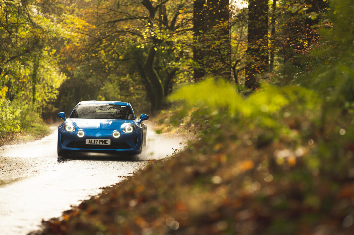 Alpine A110 conduisant à travers les flaques d'eau